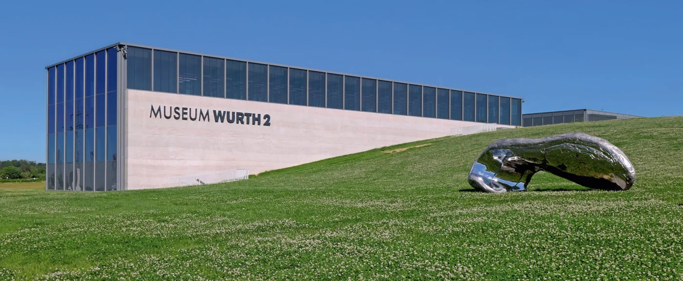 Außenansicht Museum Würth 2 mit spiegelnder Skulptur auf der Grünfläche